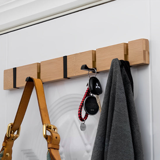 Patère mural de bois sur un mur blanc avec sac, clés et veste