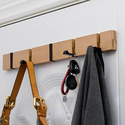 Patère mural de bois sur un mur blanc avec sac, clés et veste