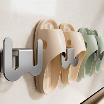 Crochet mural en forme de W avec alvéoles ondulées, fixé sur un mur blanc, vue de face 