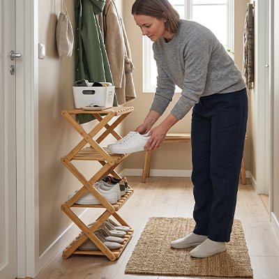 Femme qui place ses souliers sur l'étagère à chaussures