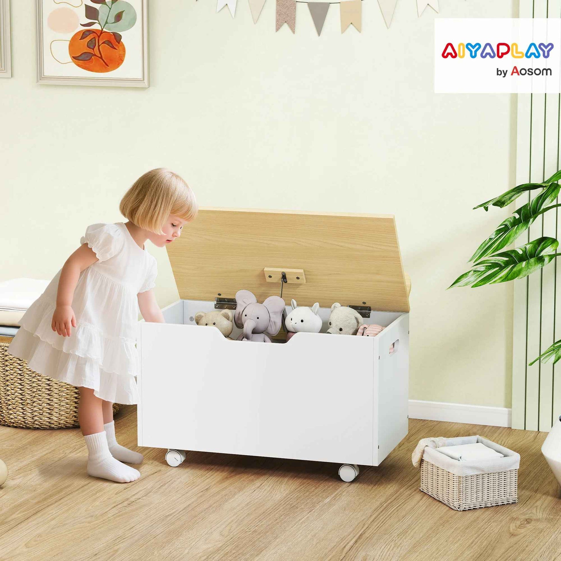 Fillette range ses peluches dans un coffre de rangement