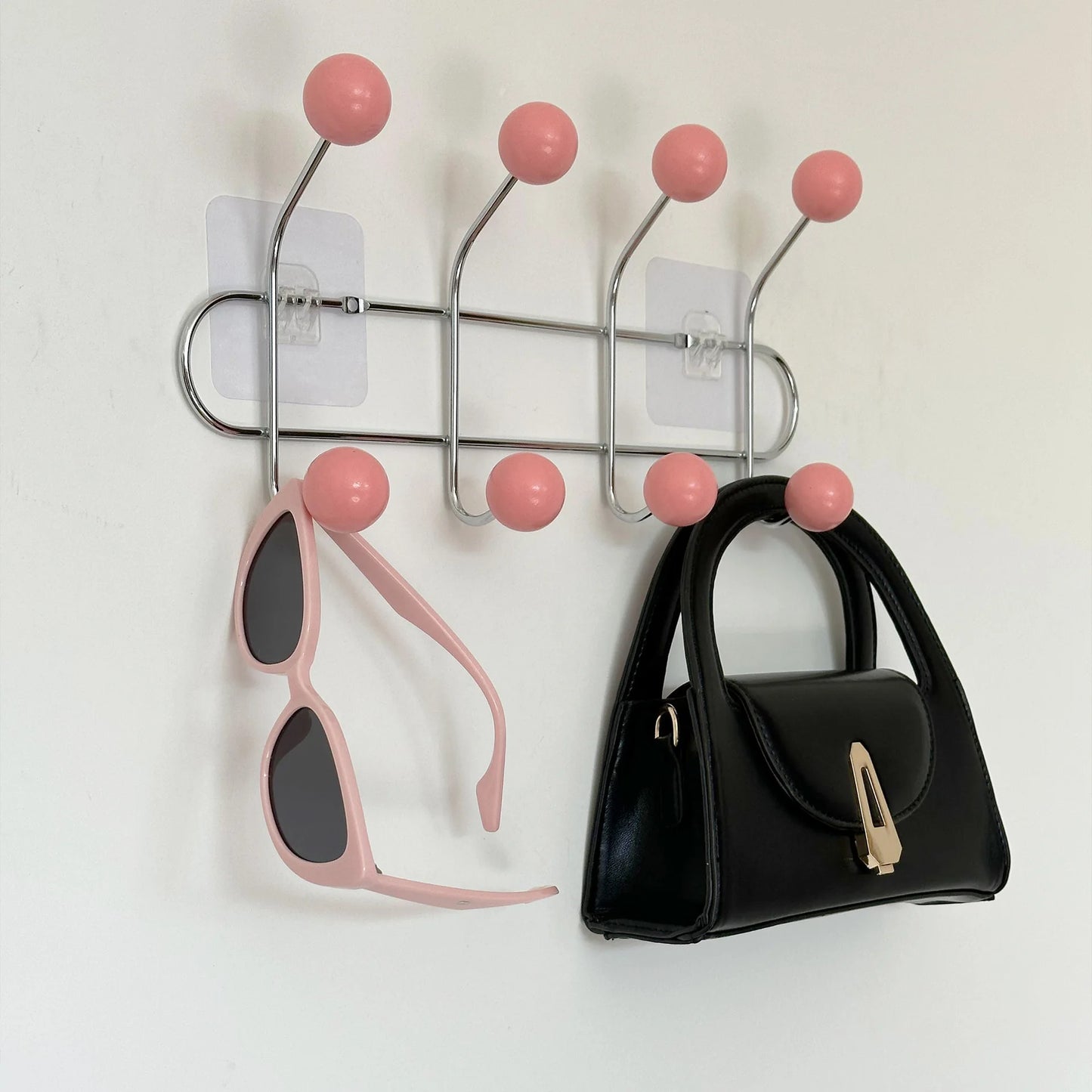 Lunette et sacoche suspendu sur les crochets de la patère rose