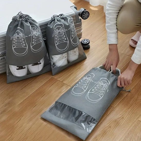 Sac à chaussures fermé avec fenêtre transparente laissant voir la paire rangée à l’intérieur 