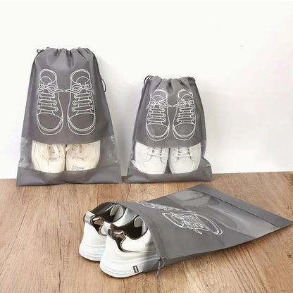 Plusieurs sacs à chaussures en nylon empilés dans un placard, chaque paire identifiable par la fenêtre transparente
